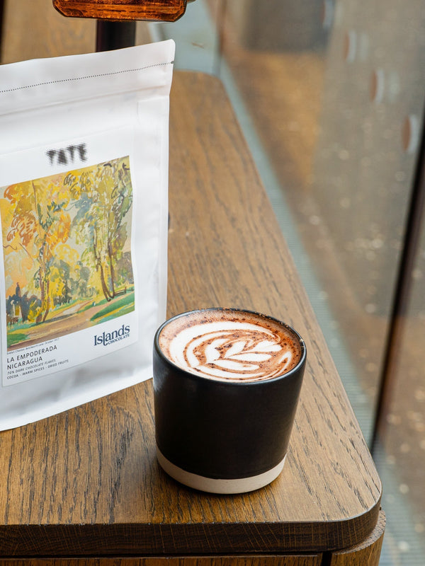 Islands Chocolate x Tate Product with hot chocolate on a wooden table